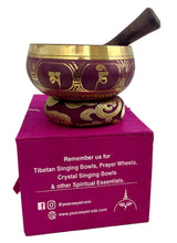 Load image into Gallery viewer, Decorative singing bowl with gold patterns on a pink box, featuring branding text.
