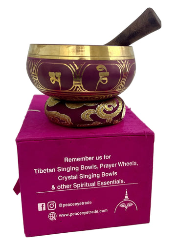 Decorative singing bowl with gold patterns on a pink box, featuring branding text.